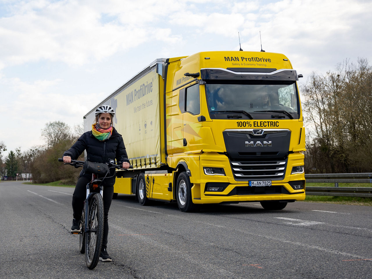 Das digitale Spiegelersatzsystem MAN Optiview erkennt die Radfahrerin auf der rechten Seite des gelben MAN Sattelzugs von MAN ProfiDrive.